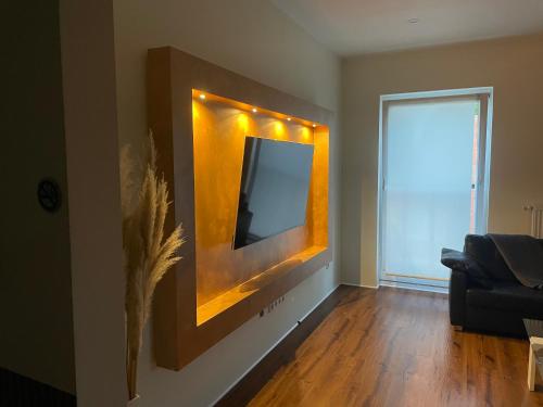 a living room with a tv on the wall at Apartament an der Landgestüt in Warendorf