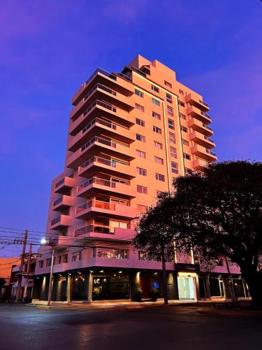 a tall building with a tree in front of it at departamento en edificio torre libertador in Río Tercero