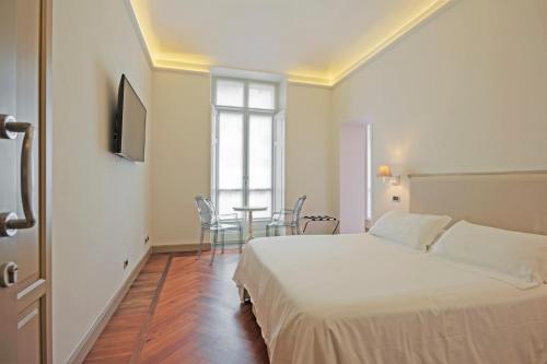 a bedroom with a bed and a table with chairs at SUYTE Torino Centro in Turin