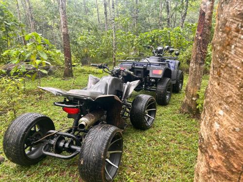 two atvs and a four wheeler parked in the woods at Trance rabara resort in Avissawella