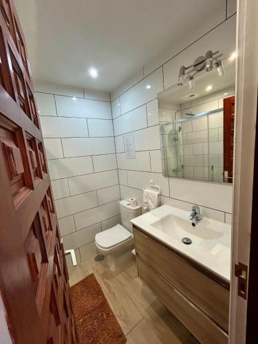 a bathroom with a sink and a toilet and a mirror at Apartamento tranquilo con vistas in Los Realejos
