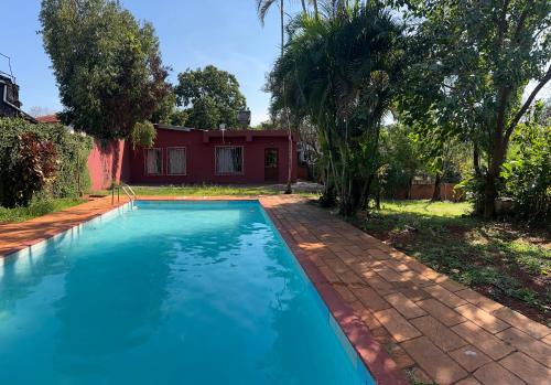 una piscina davanti a una casa di Mango Home Iguazú a Puerto Iguazú