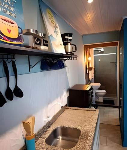 a small kitchen with a sink and a toilet at Apto Climatizado com varanda próximo a praia in Itapema
