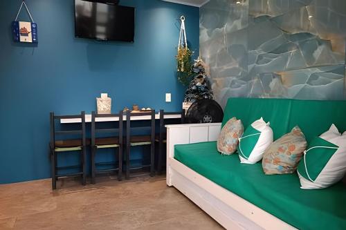 a blue room with a couch with pillows on it at Apto Climatizado com varanda próximo a praia in Itapema