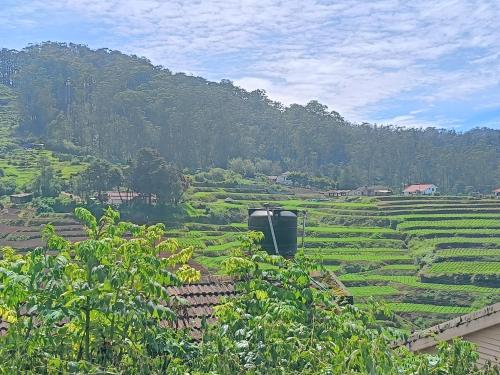 a view of a lush green field with a mountain at Mountain View Private Villa in Ooty