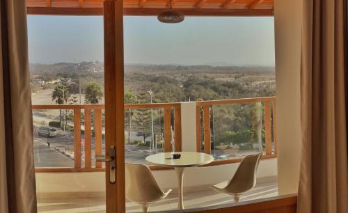 a room with a table and chairs and a large window at Cruiser Mogador Essaouira in Essaouira