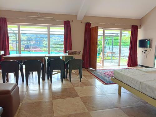 a room with a dining room table and chairs at Mountain View Private Villa in Ooty