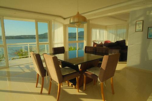 マリカーにあるParaíso da Lagoa - Piscina, Deck e Confortoのダイニングテーブルと椅子のあるリビングルーム