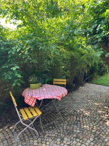 a table with two chairs and a table with a checkered table cloth at Beautiful Guest House with Sleeping Gallery in Peißenberg