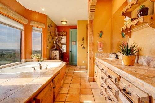 een grote badkamer met een bad en een groot raam bij Mtn-View Adobe Home with Large Deck Near Prescott! in Humboldt