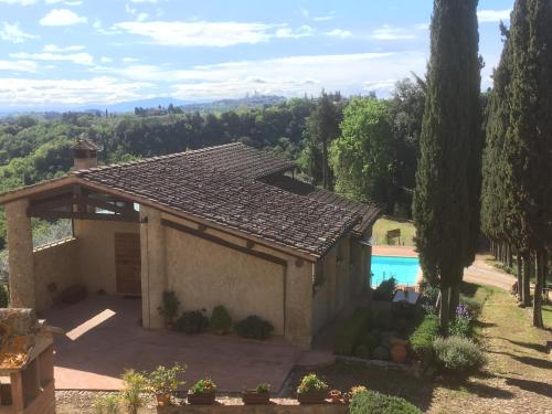 a house with a view of a pool at Podere Le Grotte in San Gimignano