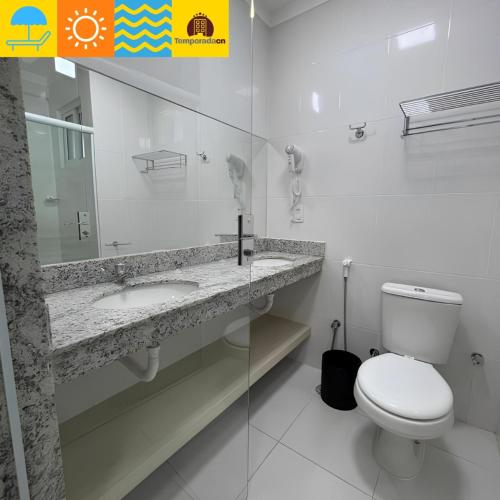 a bathroom with a toilet and a sink and a mirror at Spazzio diRoma com acesso ao Acqua Park - Temporada CN in Caldas Novas