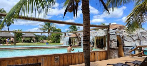 a man in a swimming pool at a resort at Eco Park Campo Grande Hotel in Campo Grande