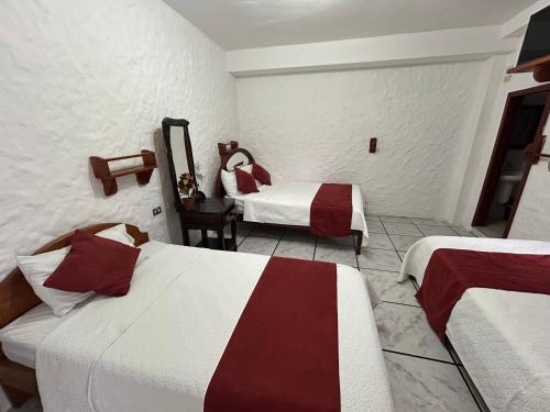 a hotel room with two beds in a room at Hostal Sir Francis Drake in Puerto Ayora