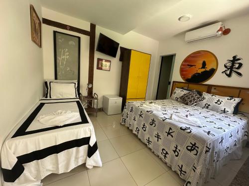 a bedroom with two beds in a room at Flor de Limão Hotel Boutique in Coroa Vermelha