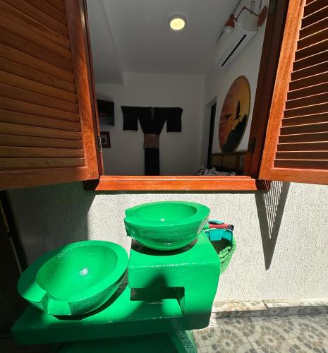 two green toilets in a bathroom with a mirror at Flor de Limão Hotel Boutique in Coroa Vermelha
