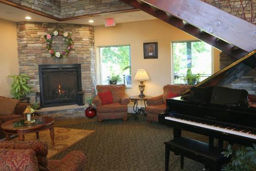 a living room with a piano and a fireplace at The Lodge at Woodstone Country Club in Danielsville