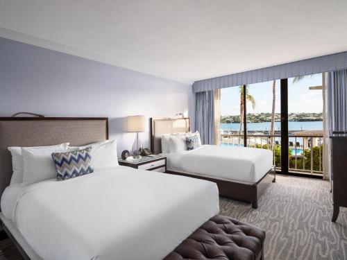 a hotel room with two beds and a balcony at Hamilton Princess & Beach Club A Fairmont Managed Hotel in Hamilton