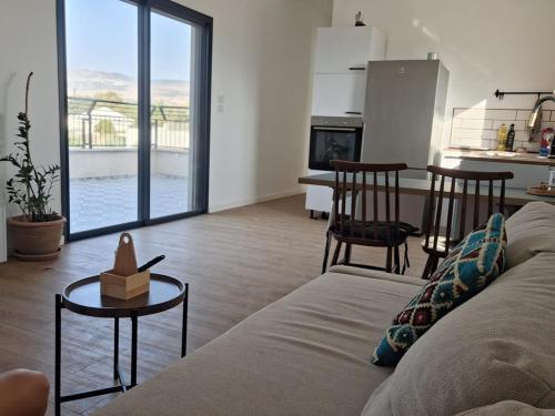 a living room with a couch and a kitchen at Mountain view in Dafna in Metsudat Menahem Ussishkin Alef