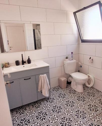 a bathroom with a toilet and a sink and mirror at Mountain view in Dafna in Metsudat Menahem Ussishkin Alef