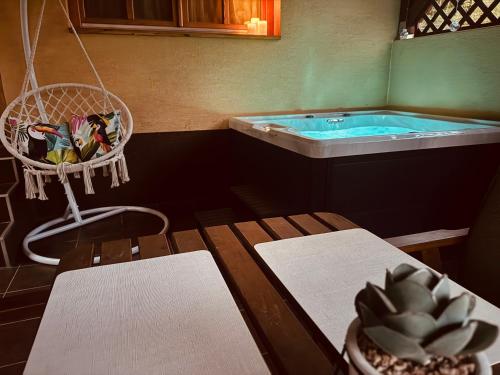 a bathroom with a tub and a table and a chair at Juhar Vendégház in Salgótarján