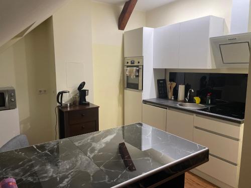 a kitchen with white cabinets and a black counter top at Apartament an der Landgestüt in Warendorf