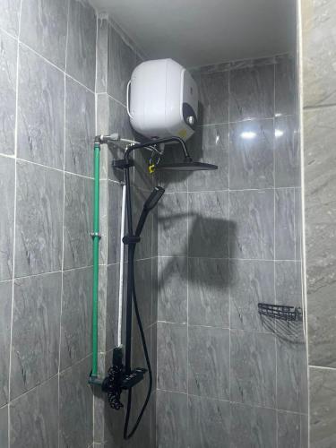 a shower in a bathroom with a shower head on a wall at Mercy Apartment in Ikeja