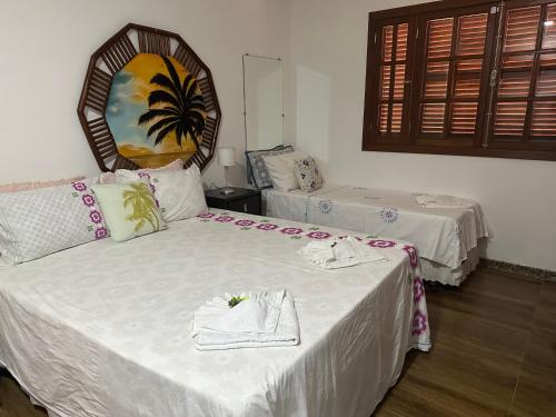 a hotel room with two beds with towels on them at Flor de Limão Hotel Boutique in Coroa Vermelha