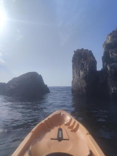 a person in a kayak in the water near some rocks at Asmanis Rooms in Tarti