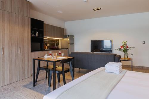 a room with a bed and a table and a couch at Stylish Studio w Gym & Pool Access VIATO HOMES in Mexico City