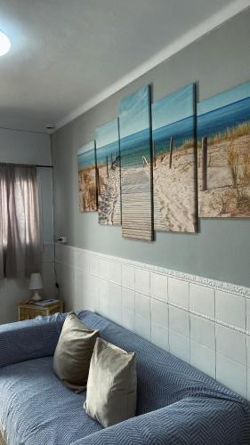 a bedroom with four paintings on the wall at Casa del Mar a la Sierra in Setenil