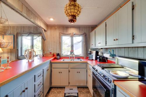 a kitchen with white cabinets and red counter tops at Spacious Kill Devil Hills Getaway with 3 Decks! in Kill Devil Hills
