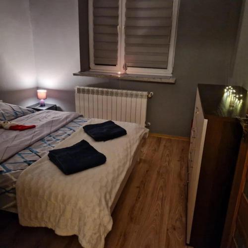 a bedroom with two towels sitting on a bed at 3-pokojowe mieszkanie do wynajęcia, Tylicz in Tylicz
