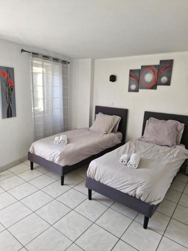 two beds sitting next to each other in a room at le Rempart in Grignan