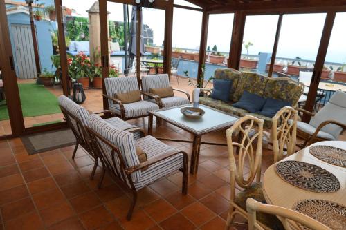 a patio with chairs and tables and a couch at Casa con jardín y jacuzzi in Realejo Alto
