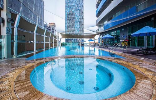 une grande piscine au milieu d'un bâtiment dans l'établissement Mayfair Luxury Apartment in 5-Star DAMAC Maison Mall Street Building, Downtown Dubai, à Dubaï
