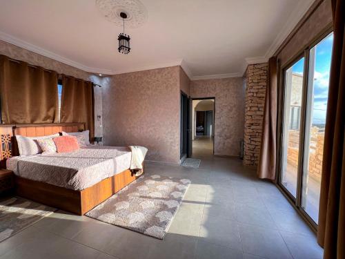 a bedroom with a bed and a large window at Room 2 Villa sunset Moulay Bouzerktoun in Essaouira