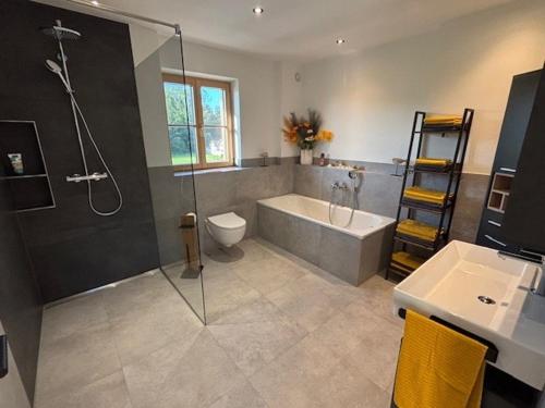 a bathroom with a shower and a tub and a sink at Entspannung auf dem Land in Dietramszell