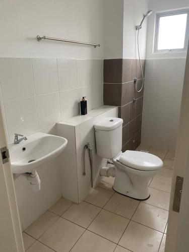 a bathroom with a toilet and a sink at Homestay TigaCahaya in Seremban