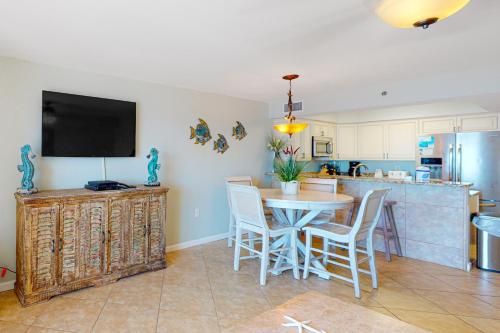 a kitchen and dining room with a table and chairs at Four Winds 902 in Orange Beach