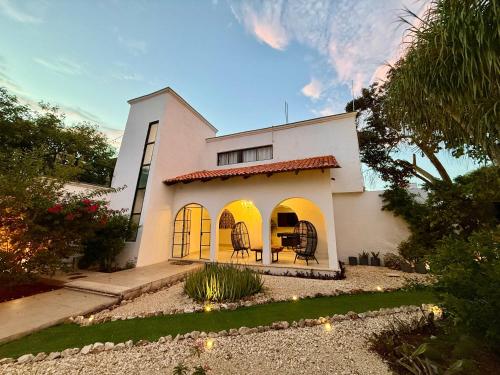 una casa bianca con porte gialle e un cortile di Bright Studio with Shared Pool Access a Mérida