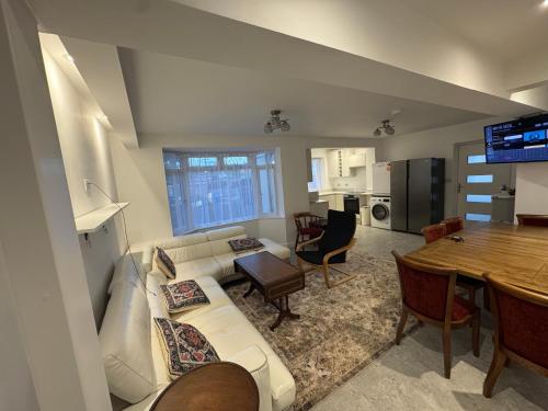 een woonkamer met een witte bank en een tafel bij Bota Property in Kidlington