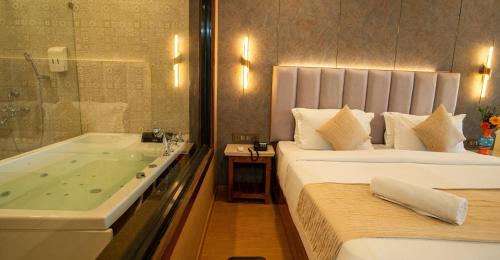 a hotel room with a bed and a bath tub at La Cabana Beach & Spa, By Ashvem Beach in Mandrem
