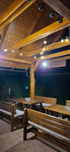 a pavilion with wooden tables and benches and lights at Vila Pohoda Javorníky s rozľahlým pozemkom in Makov