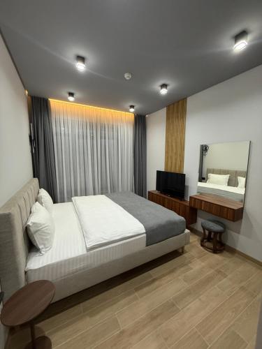 a bedroom with a bed and a vanity and a mirror at BOND HOUSE Dilijan in Dilijan