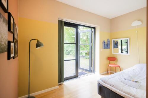 a bedroom with a bed and a sliding glass door at Lake House Central Lyngby in Kongens Lyngby
