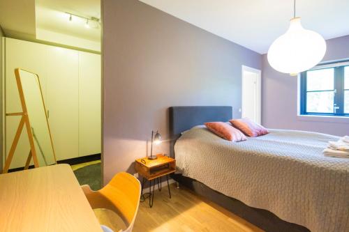 a bedroom with a bed and a table and a table at Lake House Central Lyngby in Kongens Lyngby