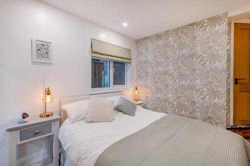 ein Schlafzimmer mit einem weißen Bett und einem Fenster in der Unterkunft Quayside Cottage in Rye