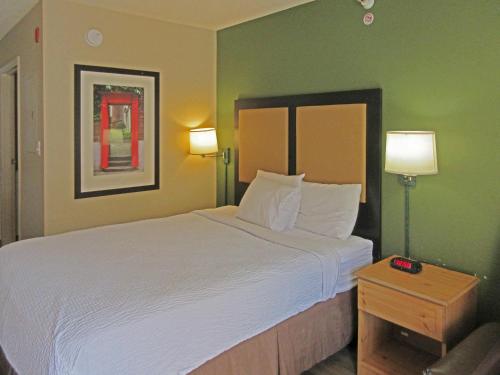 a hotel room with a large bed and two lamps at Suburban Studios Raleigh - Crabtree Valley in Raleigh