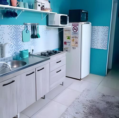 a kitchen with a refrigerator and a sink at Stúdio inteiro climatizado próximo a praia - ambiente familiar in Itapema